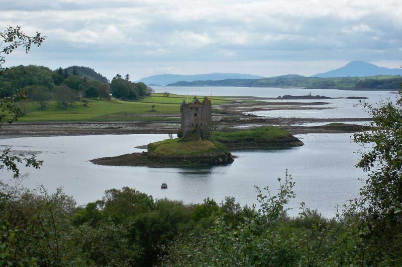 Ein steinernes Schloss steht auf einer kleinen Insel, die von ruhigem Wasser umgeben ist